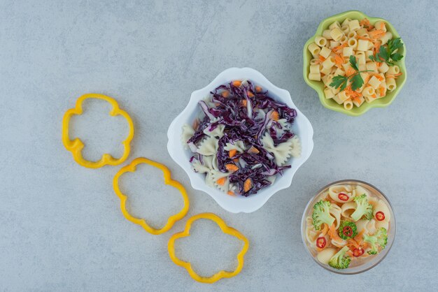 Salade de légumes sur plaque blanche avec macaroni sur fond de marbre. Photo de haute qualité