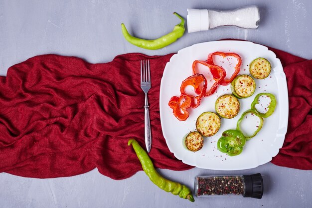 Salade de légumes en tranches dans un plateau blanc sur bleu