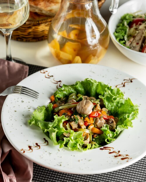 Salade de légumes verts à l'intérieur de la plaque blanche.