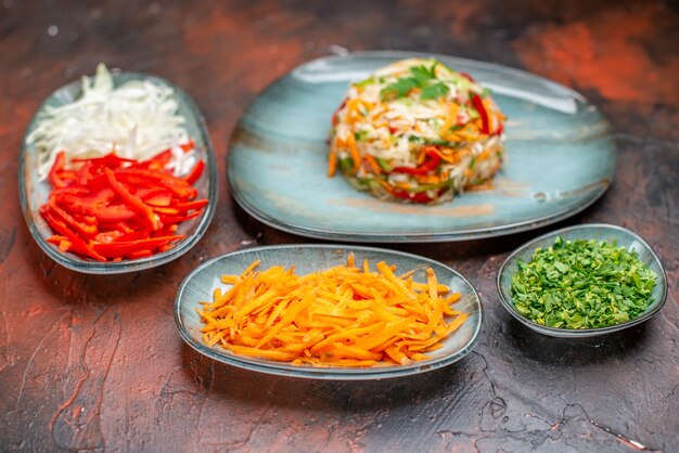 Salade de légumes vue de face avec du chou carotte tranché et des poivrons sur fond sombre nourriture diététique vie saine couleur du repas