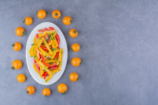 Salade de poivrons colorés hachés avec des tomates cerises à part