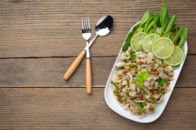 Salade de porc épicée Servie avec des tiges de chou frisé frais et croustillant Cuisine thaïlandaise.