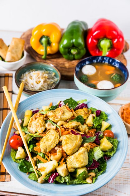 Salade de poulet avec des baguettes; soupe de boule de poisson et haricots sur table