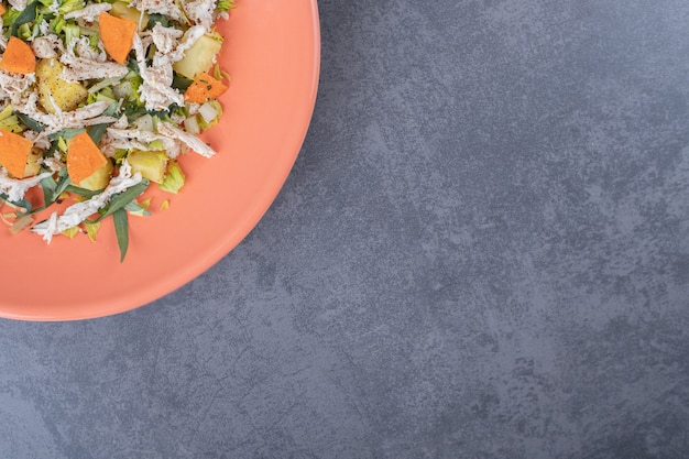 Photo gratuite salade de poulet émincé sur plaque orange.