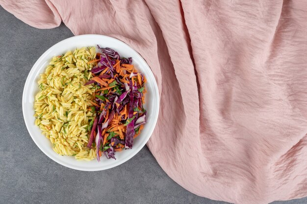 Salade de riz et de légumes cuits à la vapeur sur une assiette blanche. photo de haute qualité