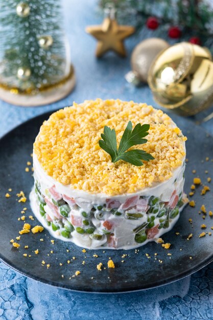 Salade russe ou salade Olivier pour le dîner de Noël sur une surface bleue