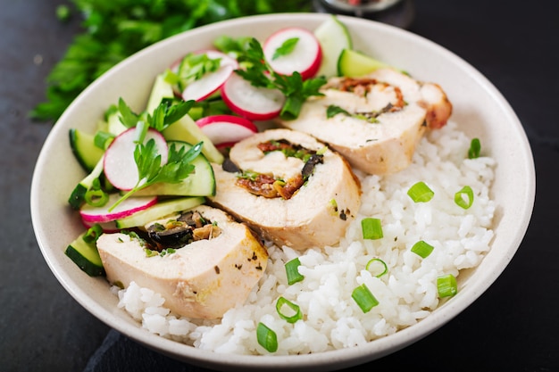 Salade saine avec des rouleaux de poulet, des radis, du concombre, de l'oignon vert et du riz. Nutrition adéquat.