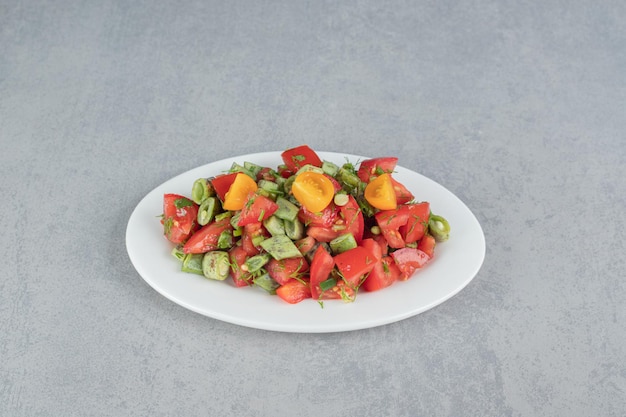 Salade de saison aux tomates cerises rouges et haricots verts.
