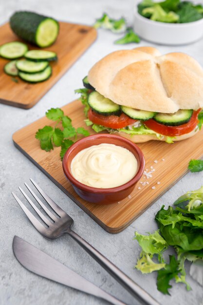 Salade avec sandwich et mayo sur planche à découper