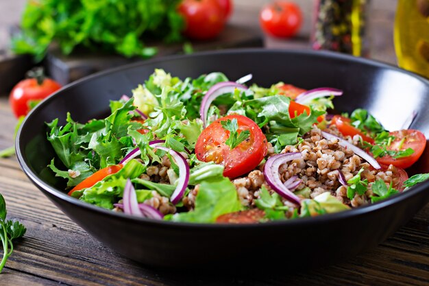 Salade de sarrasin aux tomates cerises, oignons rouges et herbes fraîches. Nourriture végétalienne. Menu diététique.