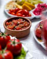 Photo gratuite salade de tomates au basilic vert oignon dans la vue de côté plat d'argile