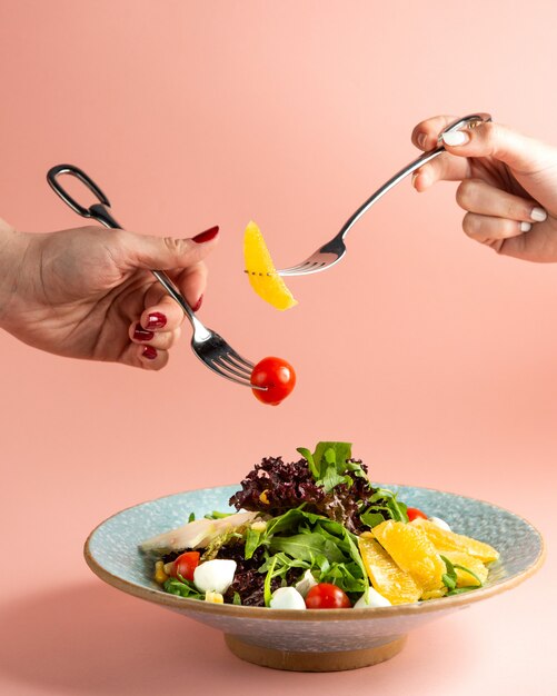 salade de tomates cerises mozzarella maïs roquette orange et pomme sur plaque