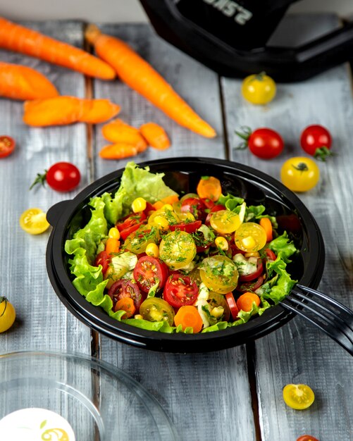 Photo gratuite salade de tomates avec diverses tomates et herbes