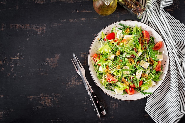 Salade de tomates avec mélange de micro-verts et de camembert.