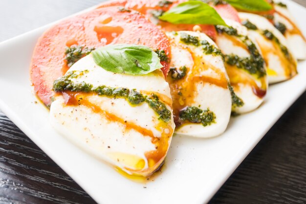 Salade de tomates et mozzarella dans une assiette blanche