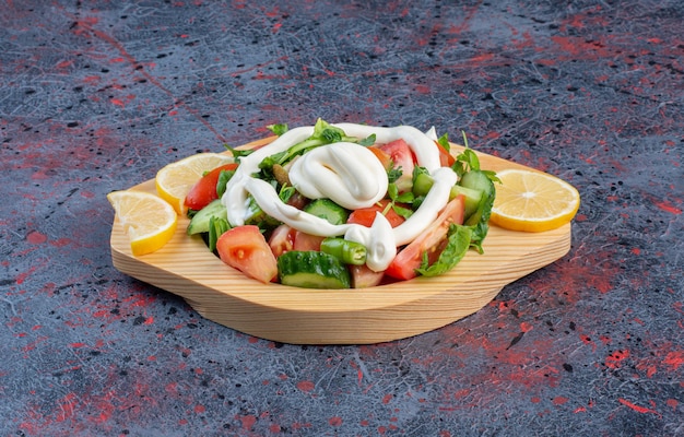 Salade verte dans un plat en bois avec sauce mayonnaise.