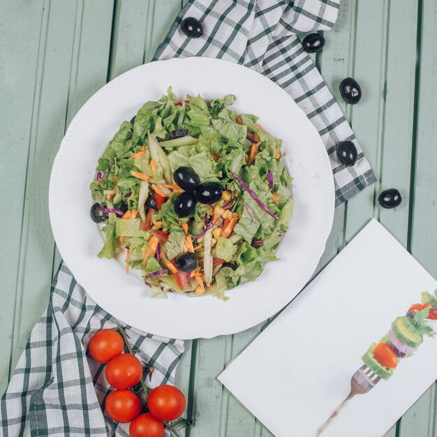 Salade verte à la laitue et aux olives noires. Vue de dessus.