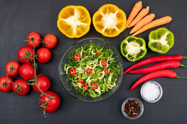 Salade verte de nourriture saine avec piment rouge tomate poivron jaune dans un bol en verre