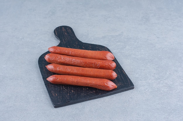 Photo gratuite salami frais sur une planche à découper en bois.