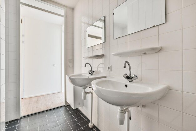 Salle de bain aux murs blancs et deux lavabos
