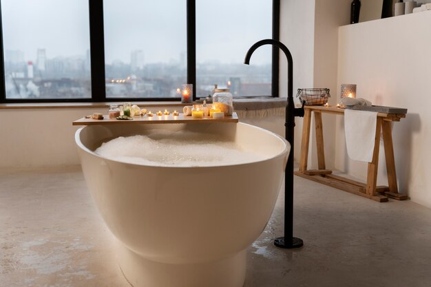 Salle de bain avec bougies et baignoire remplie d'eau