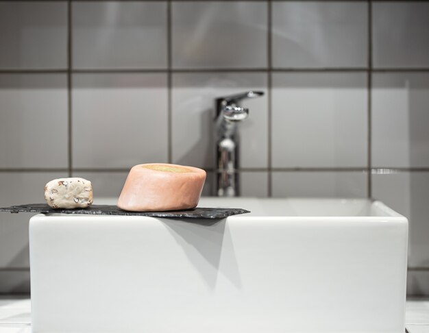 Salle de bain avec deux barres de savon fin près du lavabo. Hygiène et soins