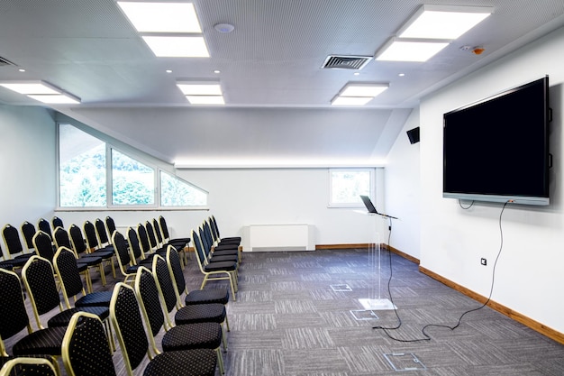 Salle de conférence sièges vides d'affilée et écran de projection avant un séminaire