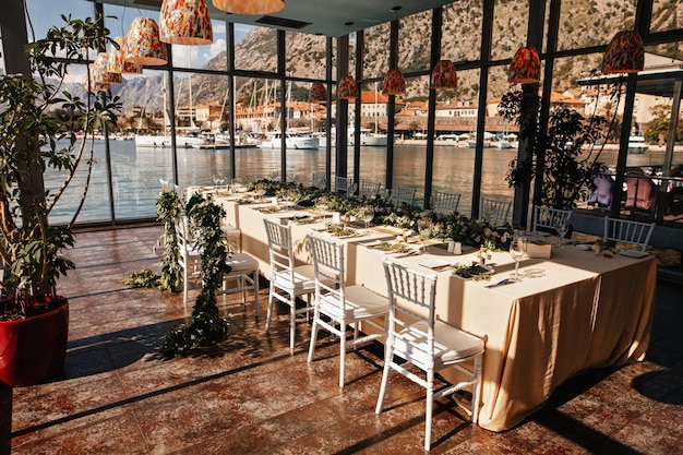 Salle de réception de mariage avec table décorée et vue sur la mer par la fenêtre