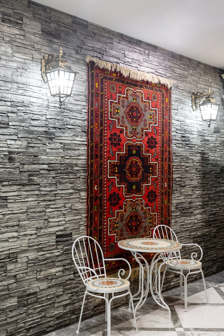 Photo gratuit salle de restaurant avec mur en pierre grise décorée de tapis azerbaïdjanais