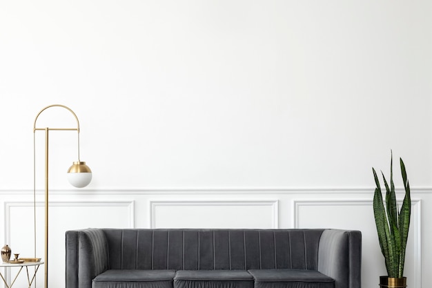 Salon chic d'esthétique de luxe moderne du milieu du siècle avec canapé en velours gris et lampe dorée