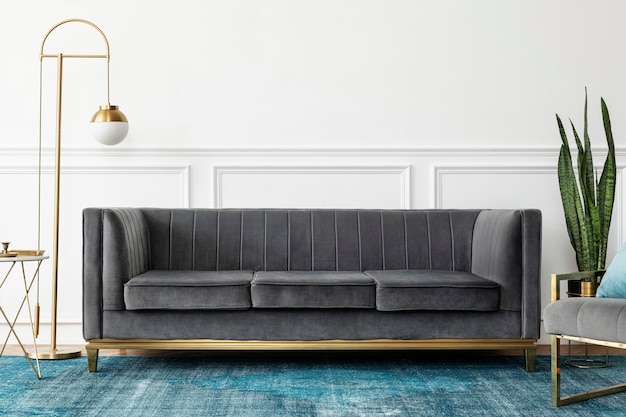 Salon chic d'esthétique de luxe moderne du milieu du siècle avec canapé en velours gris et tapis bleu