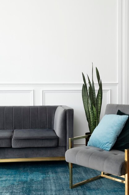 Salon chic d'esthétique de luxe moderne du milieu du siècle avec canapé en velours gris et tapis bleu