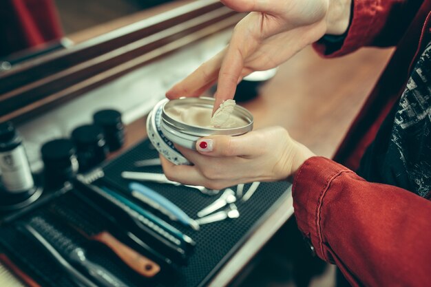 Salon de coiffure. Barbier féminin au salon. Égalité des sexes. Femme dans la profession masculine. Les mains se bouchent