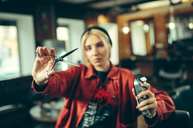 Salon de coiffure. Barbier féminin au salon. Égalité des sexes. Femme dans la profession masculine. Les mains se bouchent