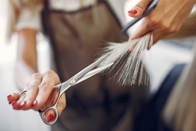Salon de coiffure coupe les cheveux de son client dans un salon de coiffure