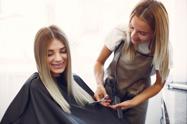 Salon de coiffure coupe les cheveux de son client dans un salon de coiffure
