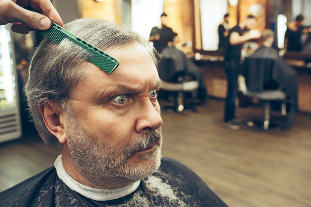 salon de coiffure faisant la coupe de cheveux vieil homme attrayant