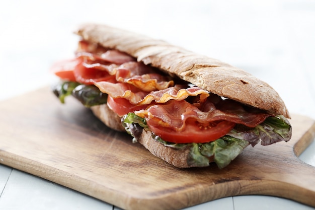 Sandwich au bacon sur une planche à découper en bois