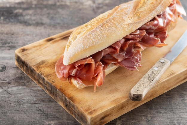 Sandwich au jambon serrano espagnol sur table en bois