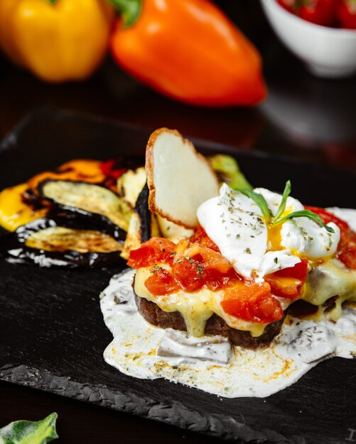 Sandwich au pain avec du fromage fondu, des tomates et des herbes.