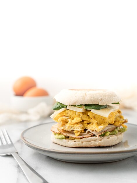 Sandwich aux œufs avec du fromage et de la laitue pour le petit déjeuner