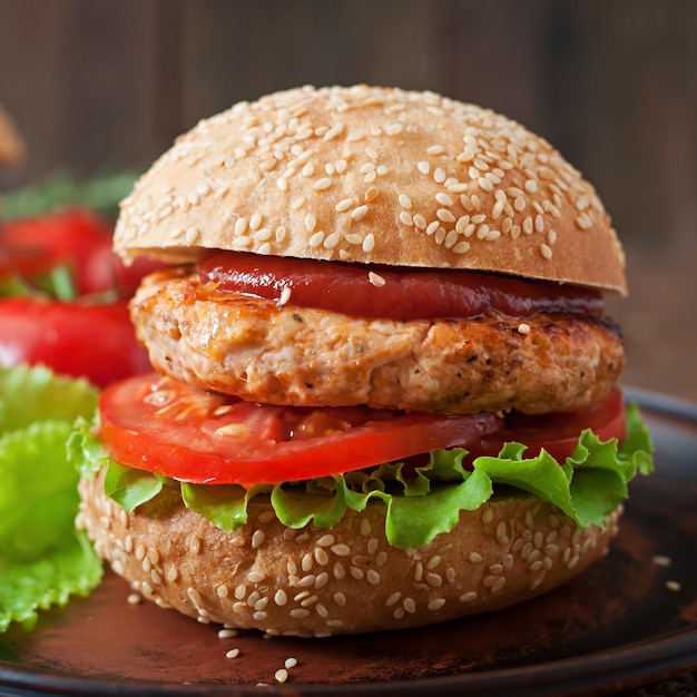 Sandwich avec burger au poulet, tomates et laitue