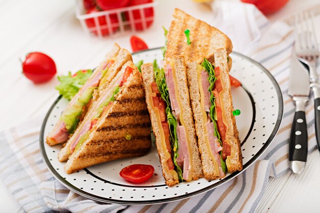 Sandwich club - panini au jambon, fromage, tomate et fines herbes.