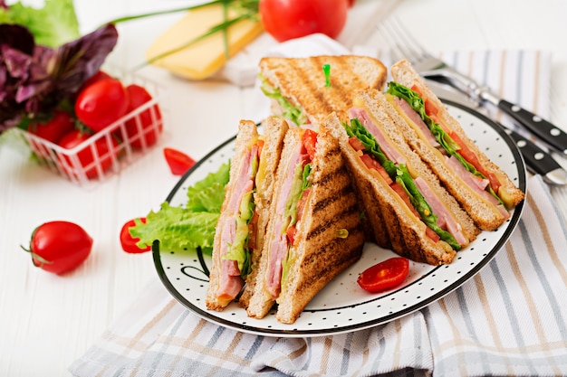 Sandwich club - panini au jambon, fromage, tomate et fines herbes.