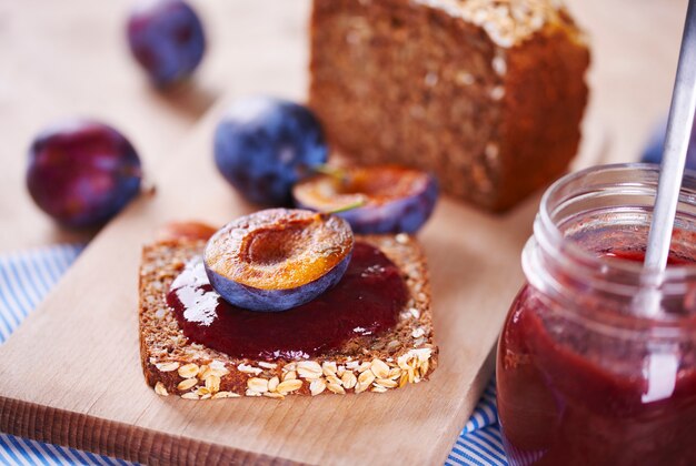 Sandwich avec confiture de prunes fraîches sur planche à découper