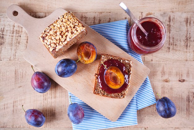 Sandwich avec confiture de prunes fraîches et prunes sur planche à découper