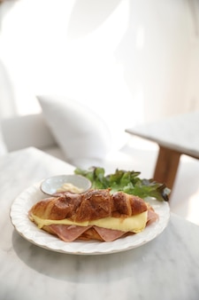 Sandwich jambon et fromage sur tableau blanc dans un café