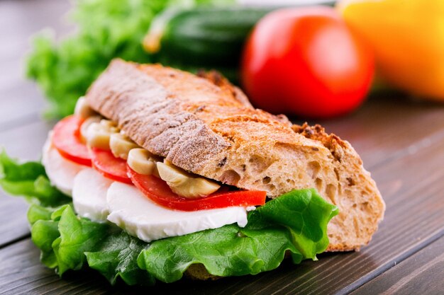 Sandwich en pain grillé avec des champignons, des tomates, des œufs et de la salade