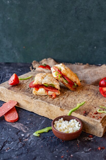 Sandwich à la saucisse turque coupé en morceaux sur une planche de bois