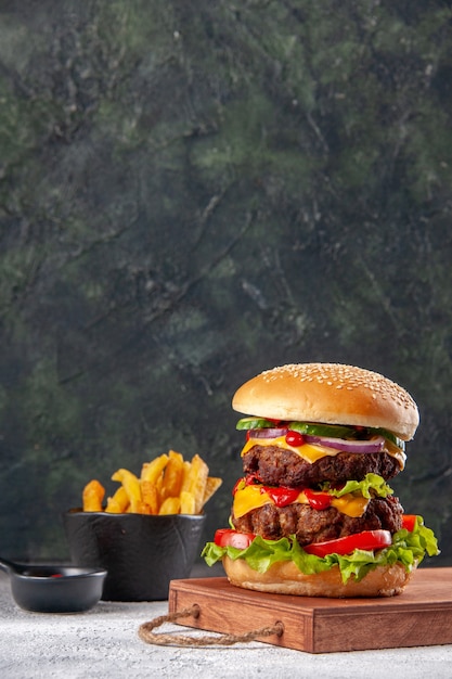 Sandwich savoureux sur des frites de planche à découper en bois sur une surface floue